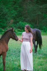A young woman and her icelandic horse working and cuddle together. Woman lovingly pets a horse in a...