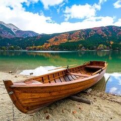 Wooden boat on the shore of a beautiful lake with autumn foliage scenery
