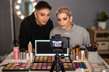 Two people filming makeup vlog with digital camera. Soft lighting. Ideal for beauty product photography, branding, or social media content.