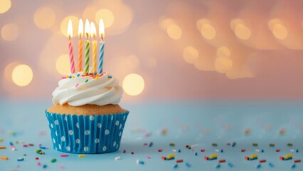 Delicious birthday cupcake on table on light background. single cupcake. The cupcake is in a blue and white polka dot wrapper, topped with white frosting and several lit