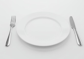 Empty plate with fork and knife ready for a meal on a plain surface in a minimalist arrangement