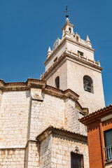 Fototapeta premium Tordesillas, Valladolid, Spain – View of the church bell tower rising above the historic town under a clear blue sky.