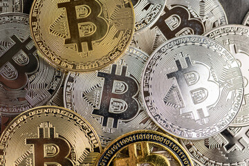 Golden and Silver Bitcoin Coins Displayed on a Stone Surface
