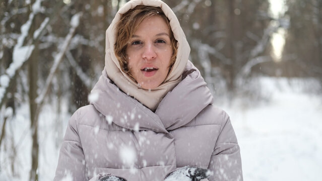 Young pretty woman in warm winter clothes walking in snowy park - Powered by Adobe