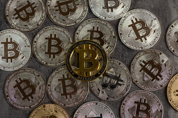 Golden and Silver Bitcoin Coins Displayed on a Stone Surface