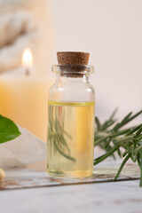 Close-up of a small bottle with essential oils near quartz and candles