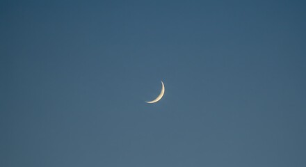 Thin crescent moon in a deep blue sky