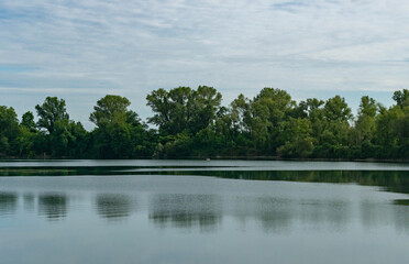 Countryside Lake with Man Fishing in Distance
