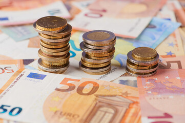 Stacks of coins and euro notes on a table depict financial growth