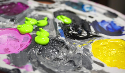 Abstract acrylic artist paint palette with neon green blobs vibrant colorful background