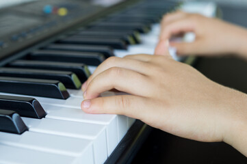 a child's hand playing an organ key