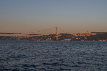 Scenic Bosphorus Strait in Istanbul at sunset with urban skyline, iconic bridges, fishing boats,...