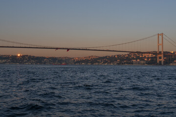 Scenic Bosphorus Strait in Istanbul at sunset with urban skyline, iconic bridges, fishing boats, and calm sea, highlighting the beauty and cultural heritage of Turkey’s most famous waterway