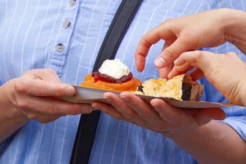 Person offering traditional desserts to friends, highlighting sharing and connection over good food...