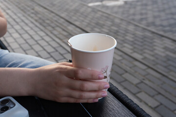 Warm beverage enjoyment in an outdoor setting during late afternoon in a city