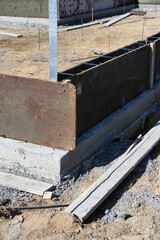 New house in beginning stage on job site, foundation dug out and wood cement forms in place, residential neighborhood housing development
