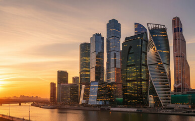 Fototapeta premium Golden Hour View Of Modern City Skyline With Glowing Buildings