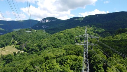 Power lines traverse a lush mountainous landscape.