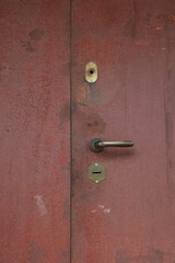Close Up Of An Old Weathered Red Metal Door With A Handle And Keyhole. Abstract Grunge Texture And...