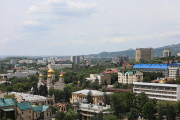 Aerial View Of Pyatigorsk City, A Spa Resort Town In Russia, With The Golden Domes Of Spassky Cathedral And Caucasus Mountains In The Background.