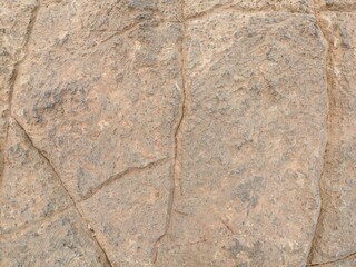Close-up of rugged natural rock texture with earthy tones and cracks