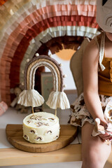 Girl eating cake. Boho style holiday. Girl's birthday in boho style. Birthday in beige and brown...