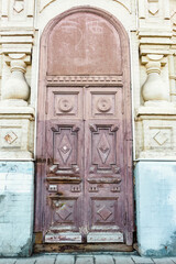 Aged wooden double doors in an ancient archway