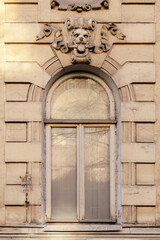 Ornate arched window on old plaster building facade