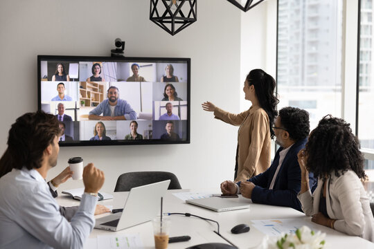 Networking and integration in modern business. Diverse polyethnic office team of coworkers hold video negotiations with remote partners meet investors online on computer screen to discuss project work - Powered by Adobe
