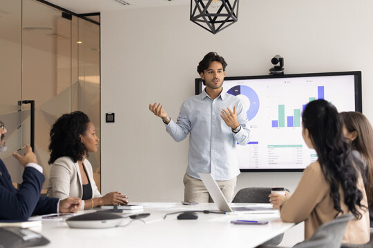 Business strategy workshop. Young professional coach expert consult diverse multiethnic employees team on education event engage businesspeople trainees in sharing ideas solutions at training seminar