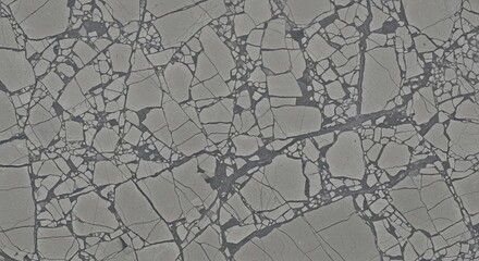 An aerial view of shattered and cracked sea ice floes creating a complex, abstract pattern on the ocean.