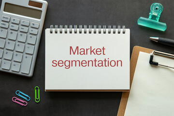 There is notebook with the word Market segmentation. It is as an eye-catching image.