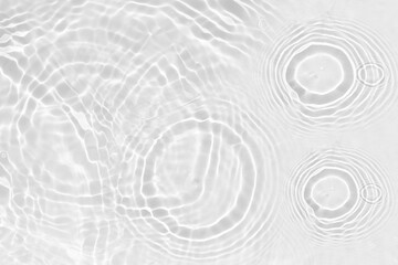 White water with ripples on the surface. Defocus blurred transparent white colored clear calm water surface texture with splashes and bubbles. Water waves with shining pattern texture background.