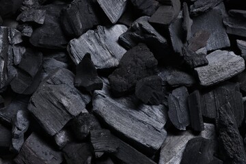 Pieces of black coals as background, top view