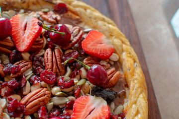 Imagen a detalle de una pizza dulce con frutos rojos y frutas secas