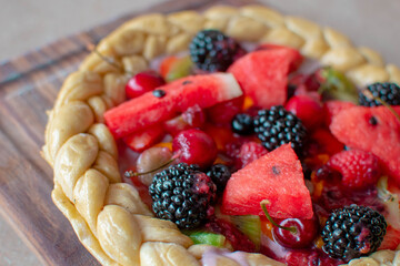 Imagen horizontal a detalle de una pizza dulce con frutos rojos