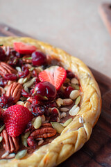 Imagen vertical de una pizza de chocolate con frutas y frutos secos