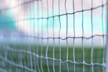 Close-up of soccer goal netting with blurred field in background