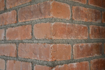 Corner of red brick building. Dirty white grout.