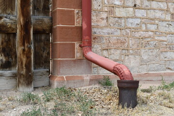 Modern downspout on classic stone structure.