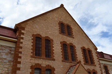 Looming prison complex main hall. Exterior windows covered in iron bars.