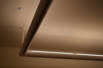 Fluorescent lighting pointed upward. One solid light strip taking ninety degree turn.