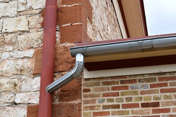 Modern gutter system linked with vintage downpipe.