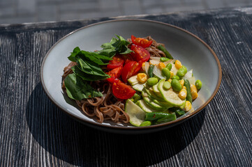 Top view of a dish of buckwheat noodles with vegetables. 