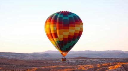 Obraz premium Colorful hot air balloon ascending over scenic landscape.