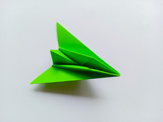Green airplane origami isolated on white background.