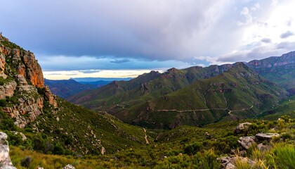 Naklejka premium Lush mountain valley scene under a dramatic sky.