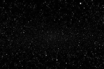 Starry night sky.  Vast expanse of black space speckled with numerous tiny, bright stars