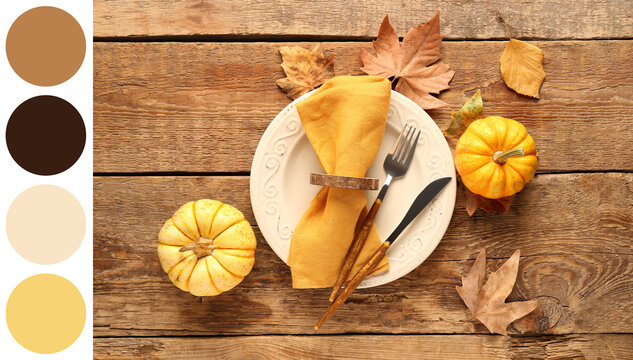 Beautiful table setting with fresh pumpkins and autumn leaves on wooden background