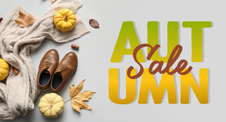 Composition with stylish children's shoes, scarf, pumpkins and fallen leaves on grey background